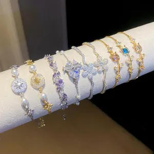 Selezione di raffinati braccialetti con fiori di zircone e perle su supporto bianco