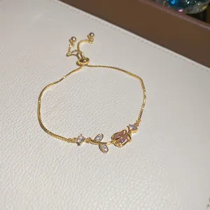 Primo piano del bracciale a tulipano dorato con zircone rosa e dettagli in pietra brillante