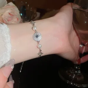 Dettaglio di un bracciale in argento con perle e un ciondolo a stella in zircone lucido