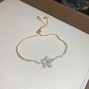 Dettaglio di un elegante bracciale a fiore in oro con pietre di zircone e catena regolabile