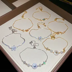 Dettaglio di lussuosi bracciali con fiori in zircone e temi celesti in vassoio portagioie