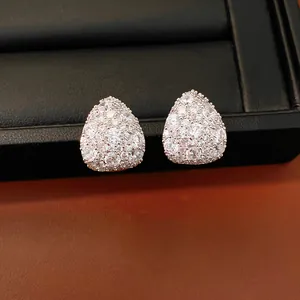 Macro detail of teardrop stud earrings pavé-set with brilliant white cubic zirconia