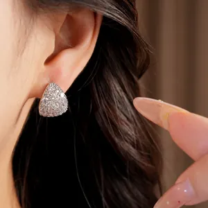 Detailed view of sparkling teardrop-shaped silver needle zircon stud earrings worn on ear