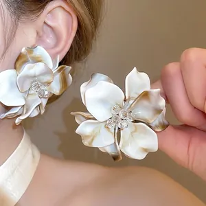 Elegant oversized cream acrylic flower stud earrings with a shiny crystal center