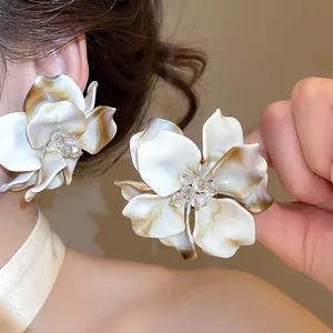 Detailed view of acrylic flower earrings with crystal bead center and marble pattern