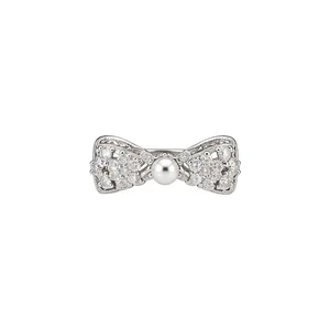 Dainty silver bow-shaped ear clip featuring shimmering zircons and a central pearl accent
