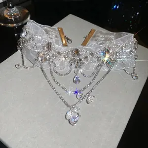 Macro view of French vintage lace choker with sparkling crystal flower and dangling pendants.