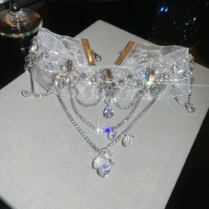 Macro detail of white lace choker necklace with sparkling crystals and teardrop pendants