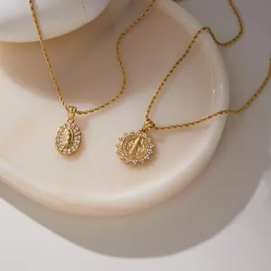 Nahaufnahme von goldenen religiösen Porträt-Anhängern mit Seilkette aus Titanstahl