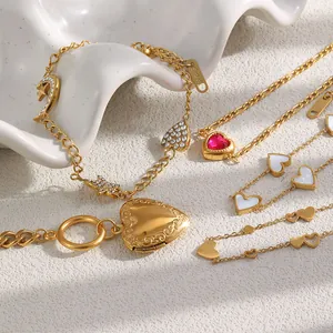 Macro view of multiple gold-plated stainless steel heart and star charm bracelets