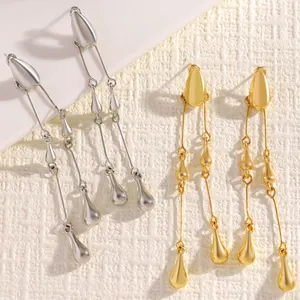 Macro detail of gold and silver long tassel teardrop earrings with matte finish