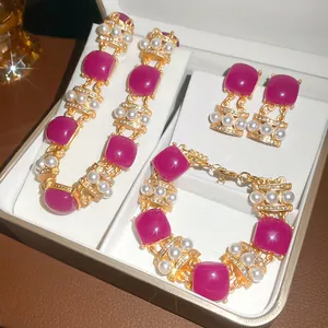 Close-up detail of vintage jewelry set featuring purple resin squares and pearls in a cream box
