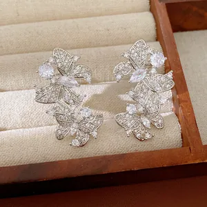 Dettaglio di orecchini a farfalla in zircone con placcatura in oro 18 carati