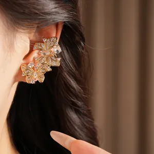 Vista dettagliata di eleganti orecchini a farfalla placcati in oro 18k con zirconi