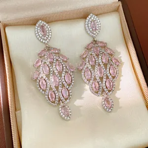 Vista dettagliata di orecchini vintage in argento con zirconi rosa e pietre micro-pave.