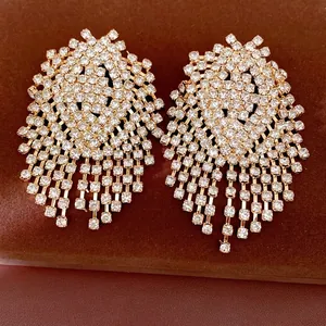 Luxury geometric tassel statement earrings with shimmering rhinestones on brown display.