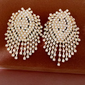 Detailed close-up of geometric rhinestone tassel earrings with a sparkling gold finish
