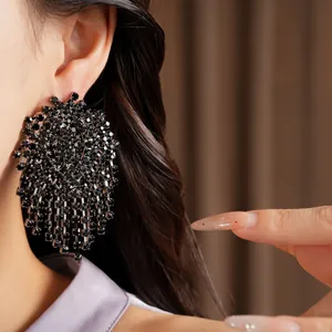 Close-up of elegant black rhinestone geometric tassel earrings worn by an Asian model
