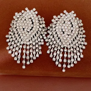 Macro view of oversized rhinestone tassel earrings with silver needles and luxury finish.