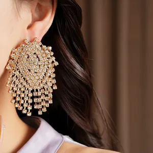 Close-up of luxury gold-toned tassel earrings with shimmering white rhinestones