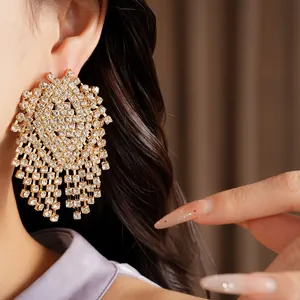 Detailed view of luxury gold-tone geometric tassel earrings with shimmering rhinestones