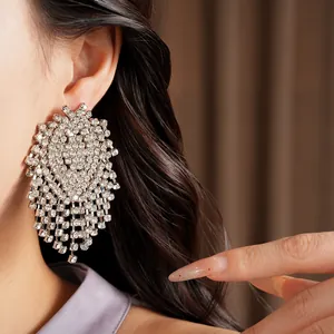 Detail view of silver needle geometric tassel earrings with luxury sparkling rhinestones
