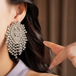 Detailed close-up of a sparkling rhinestone geometric tassel earring worn on ear
