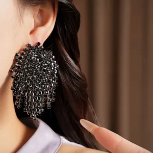 Close-up view of elegant black rhinestone geometric tassel earrings on model's ear
