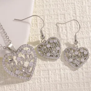 Detailed close-up of heart-shaped Mama pendant and earrings set with sparkling zircons