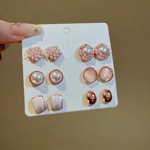 Elegante juego de 6 pares de pendientes de perlas rosas en una tarjeta de exhibición