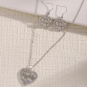 Close-up of silver heart-shaped necklace and earrings set with MaMa and cubic zirconia