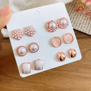 Detalle de un juego de 6 pares de pendientes de perlas y oro rosa en tarjeta blanca