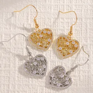 Close-up of gold and silver heart-shaped 'MaMa' earrings with sparkling zircon stones