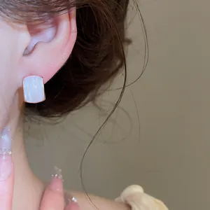 Primer plano detallado de elegantes pendientes rectangulares de perlas en oro rosa