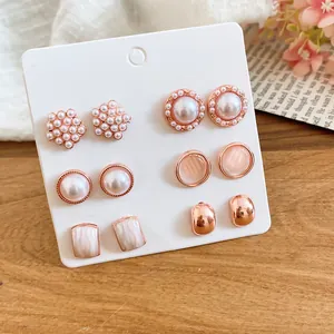 Detalle de primer plano de un elegante juego de pendientes de perlas con detalles en oro rosa