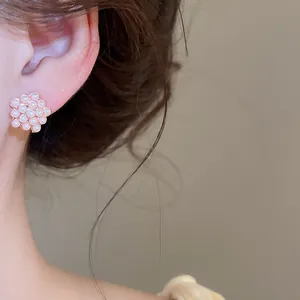 Primer plano de elegantes pendientes de perlas de racimo usados por una modelo