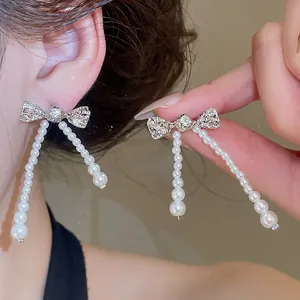 Elegant bow-knot pearl tassel earrings with shimmering zircon center for a vintage look.