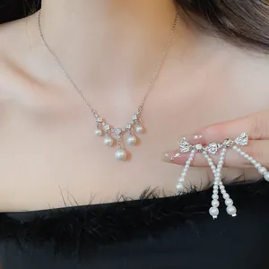 Close-up of elegant French vintage zircon and pearl necklace with matching bow earring