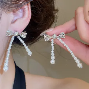 Close-up of elegant French vintage bow earrings with exquisite zircon and dangling pearls