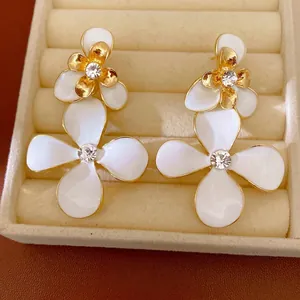 Eleganti orecchini a fiore in smalto bianco con placcatura in oro e cristalli lucenti