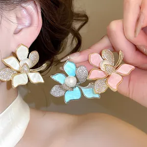 Detailansicht der 18K vergoldeten Blumen-Ohrstecker mit Perlen und funkelnden Zirkonen.