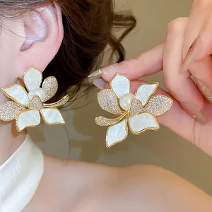 Detailansicht von 18K vergoldeten Blumenohrringen mit Zirkon und zentraler Perlenverzierung