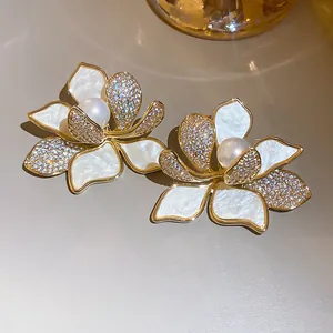 Detailansicht vergoldeter Blumenohrringe mit Zirkonia-Besatz und zentralen Perlen
