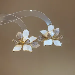 Detailansicht der 18K vergoldeten Blumen-Ohrstecker mit glitzerndem Zirkonia und Perlen
