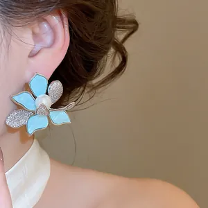 Nahaufnahme der eleganten Blumen-Perlenohrringe mit blauen Blüten und Zirkonia.