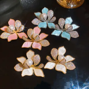 Detailansicht von floralen Zirkon-Perlenohrringen in den Varianten Rosa, Blau und Weiß