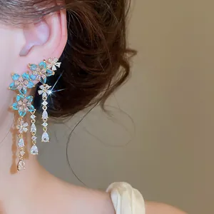 Dettaglio di eleganti orecchini a nappa floreale con zirconi scintillanti su orecchio.