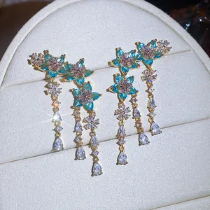Primo piano di eleganti orecchini a fiore con zirconi blu e rosa per donne raffinate