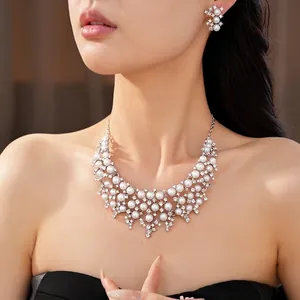 Parure de bijoux élégante en perles et strass avec collier et boucles d'oreilles sur modèle