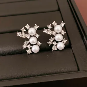 Vue détaillée d'élégantes boucles d'oreilles en perles et strass sur un plateau à bijoux noir